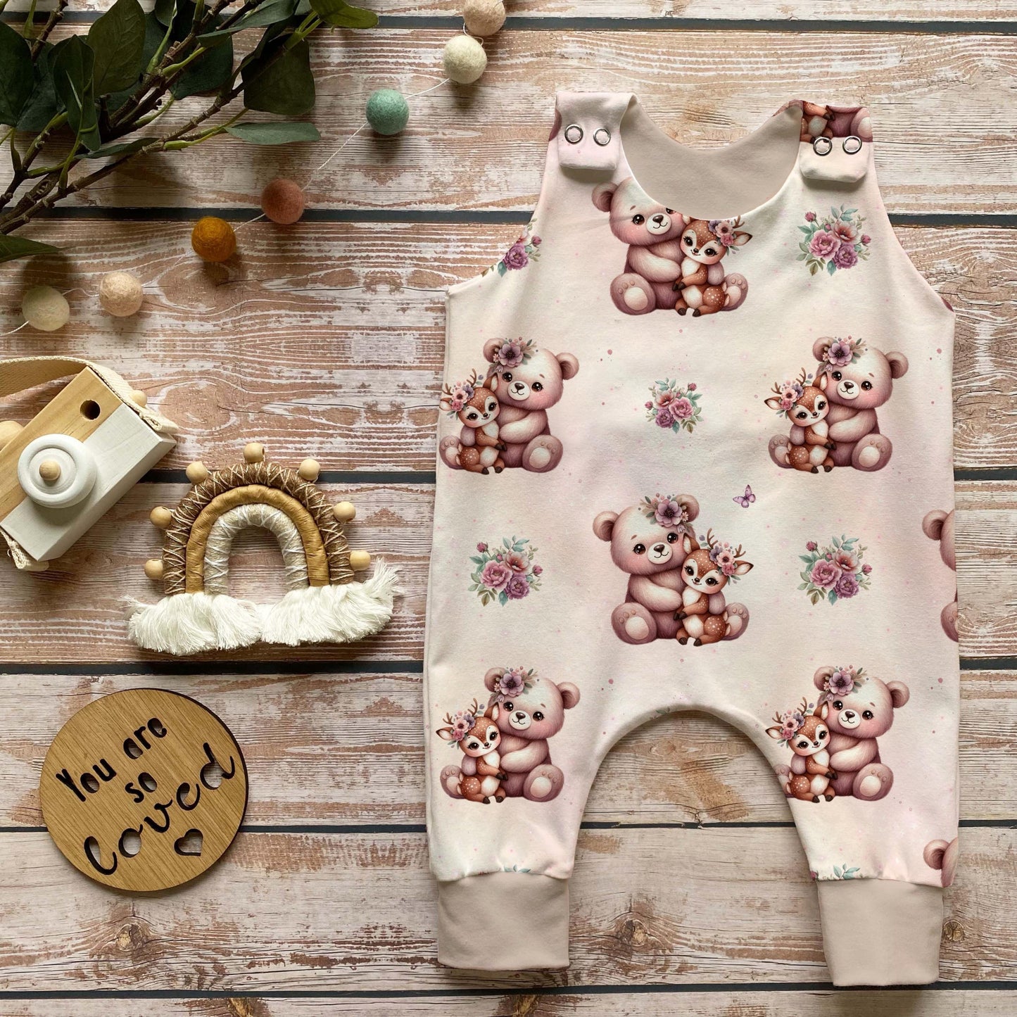 Nähbeispiel: Baby Strampler mit Waldtier-Stoffdesign in Rosa, liebevoll genäht. Perfekt für kreative DIY-Kinderkleidung.
